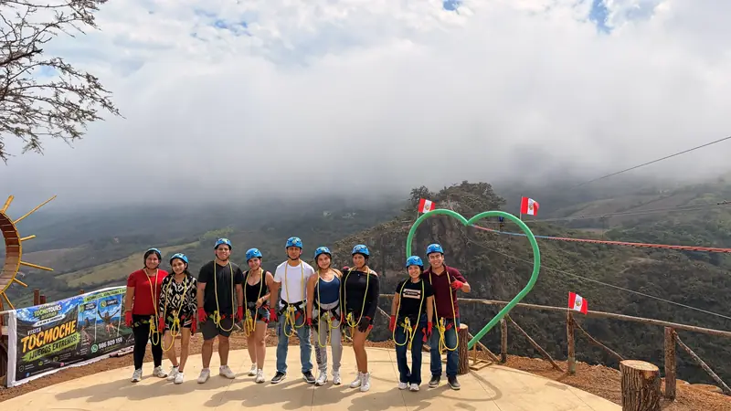 Grupo de visitantes en el mirador de Tocmoche junto al corazón verde y las banderas