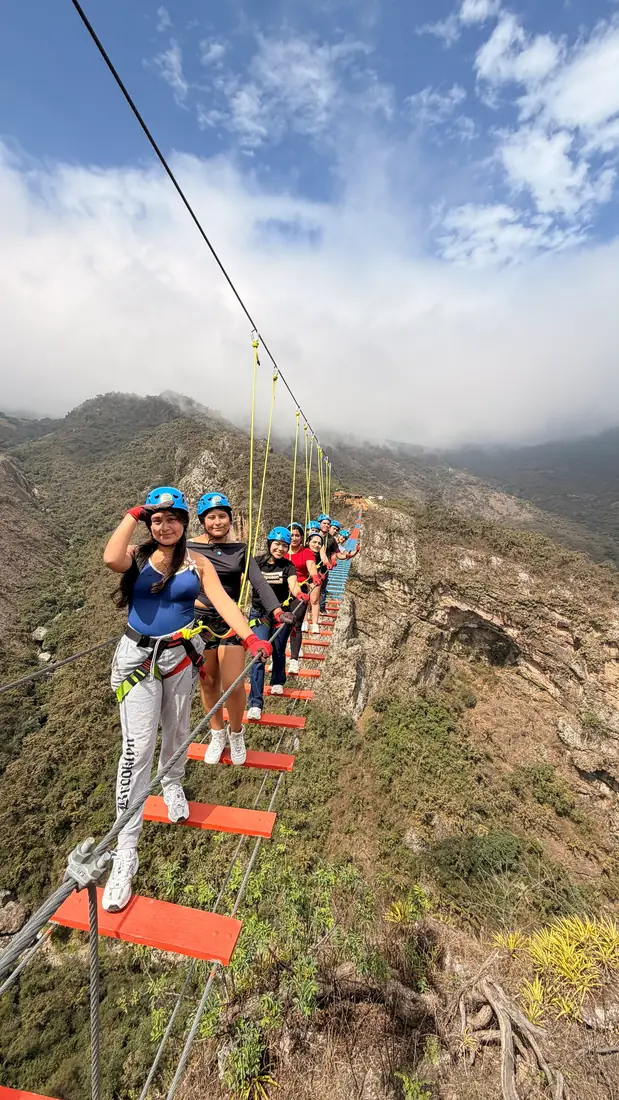 Viajera avanzando por el puente colgante seguida por el resto del grupo