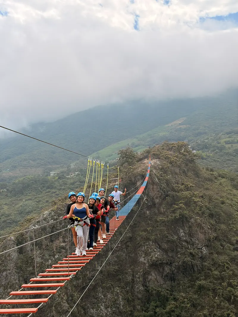 Viajeros avanzando por el puente tibetano sobre el valle de Tocmoche