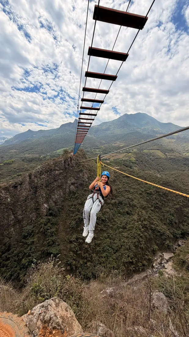 Persona suspendida en el canopy sobre la vegetación del valle