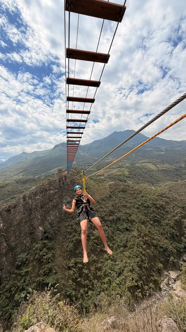 Viajera descendiendo por el cable del canopy entre los cerros