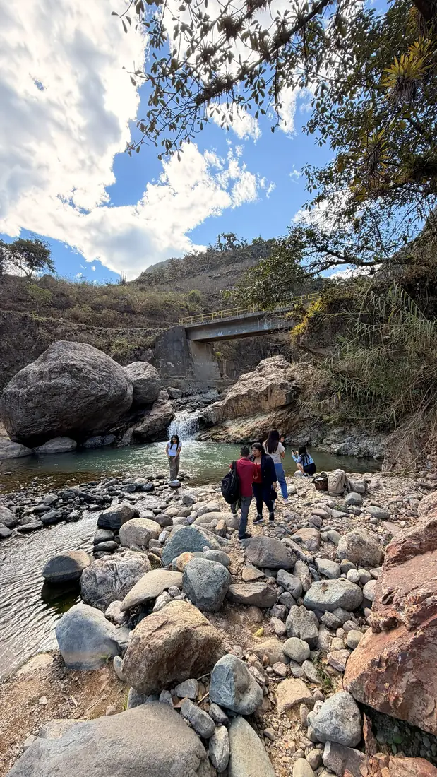 Visitantes caminando entre las piedras del río de Tocmoche