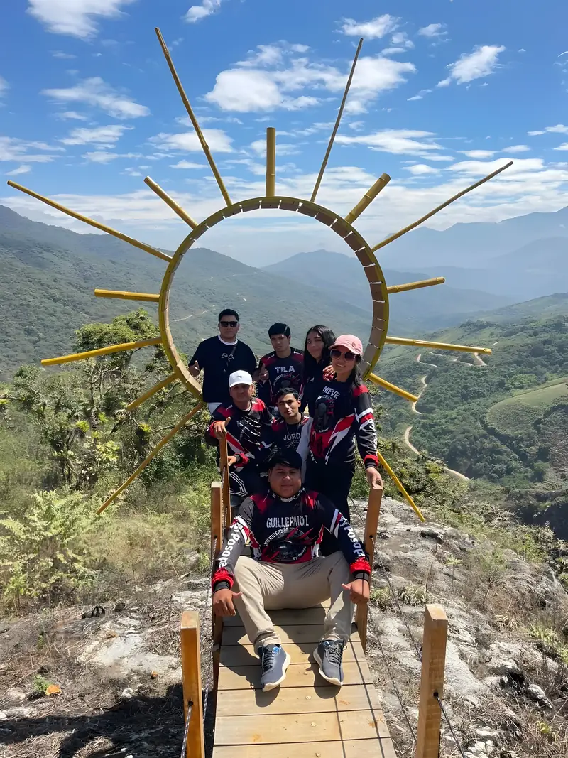Grupo posando bajo el arco del sol en el mirador del Parque Turístico