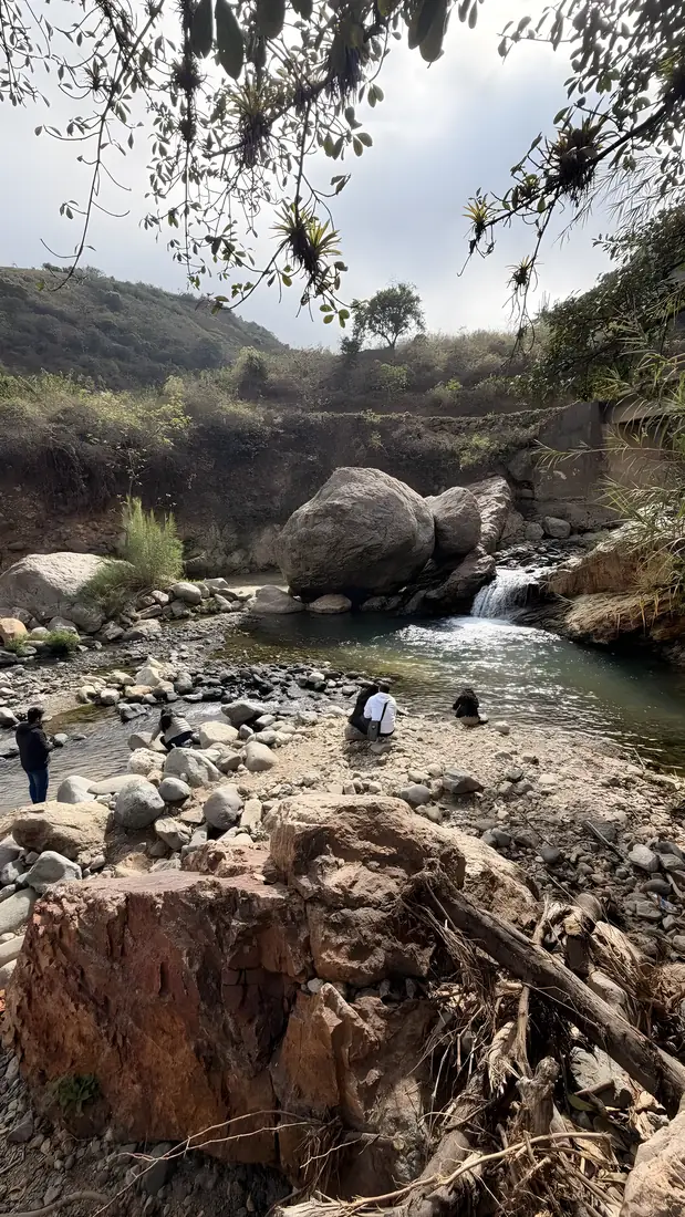 Poza del río con una pequeña caída de agua entre las rocas
